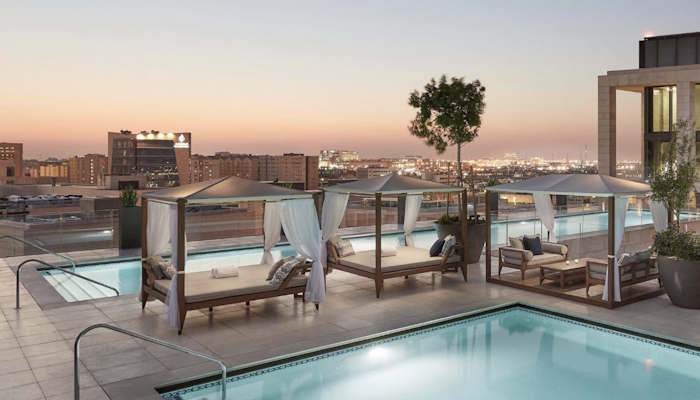 Mandarin Oriental, Doha Rooftop pool with lounge cabanas and city skyline views at sunset