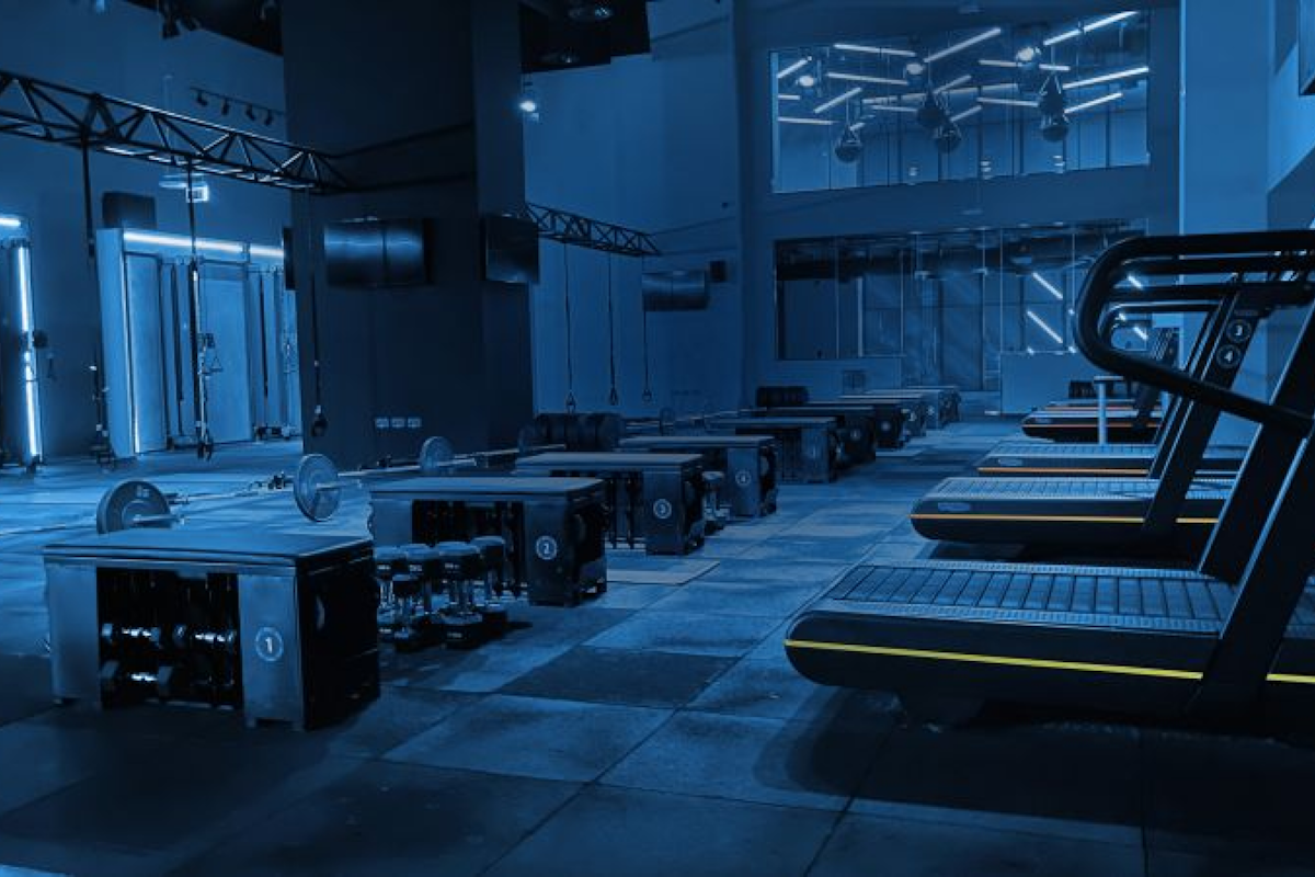 Dark-toned gym with modern fitness equipment and blue lighting