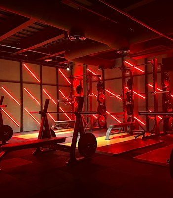SoulHIIT Gym with intense red lighting, highlighting the workout equipment and creating an energizing atmosphere.