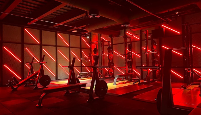 SoulHIIT Gym with intense red lighting, highlighting the workout equipment and creating an energizing atmosphere.