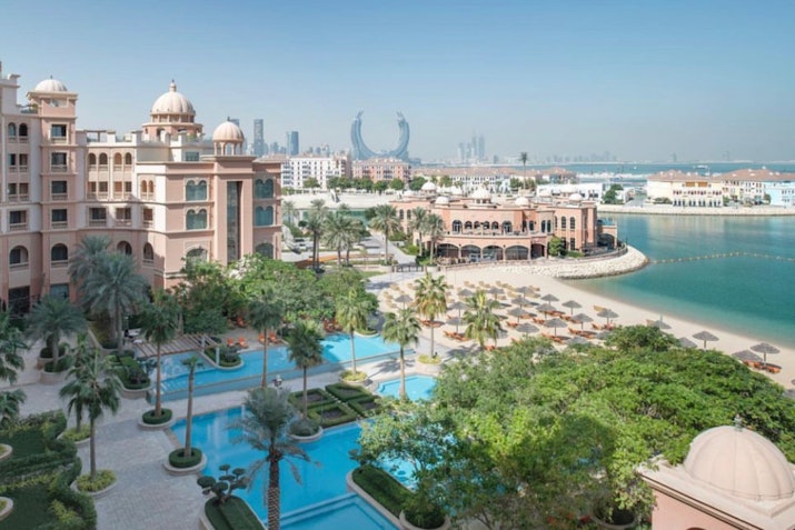 Kempinski Marsa Malaz View of a luxury resort with pools and beach, featuring modern architecture in the background