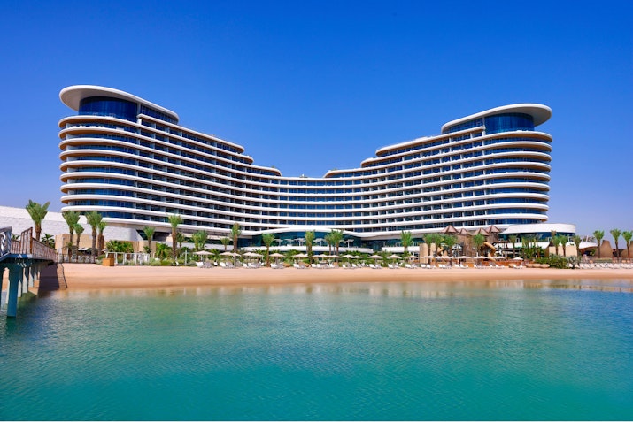 Luxury beachfront hotel with modern architecture and clear blue skies