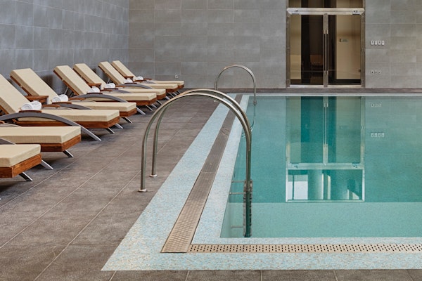 Indoor pool area with lounge chairs and soft lighting.