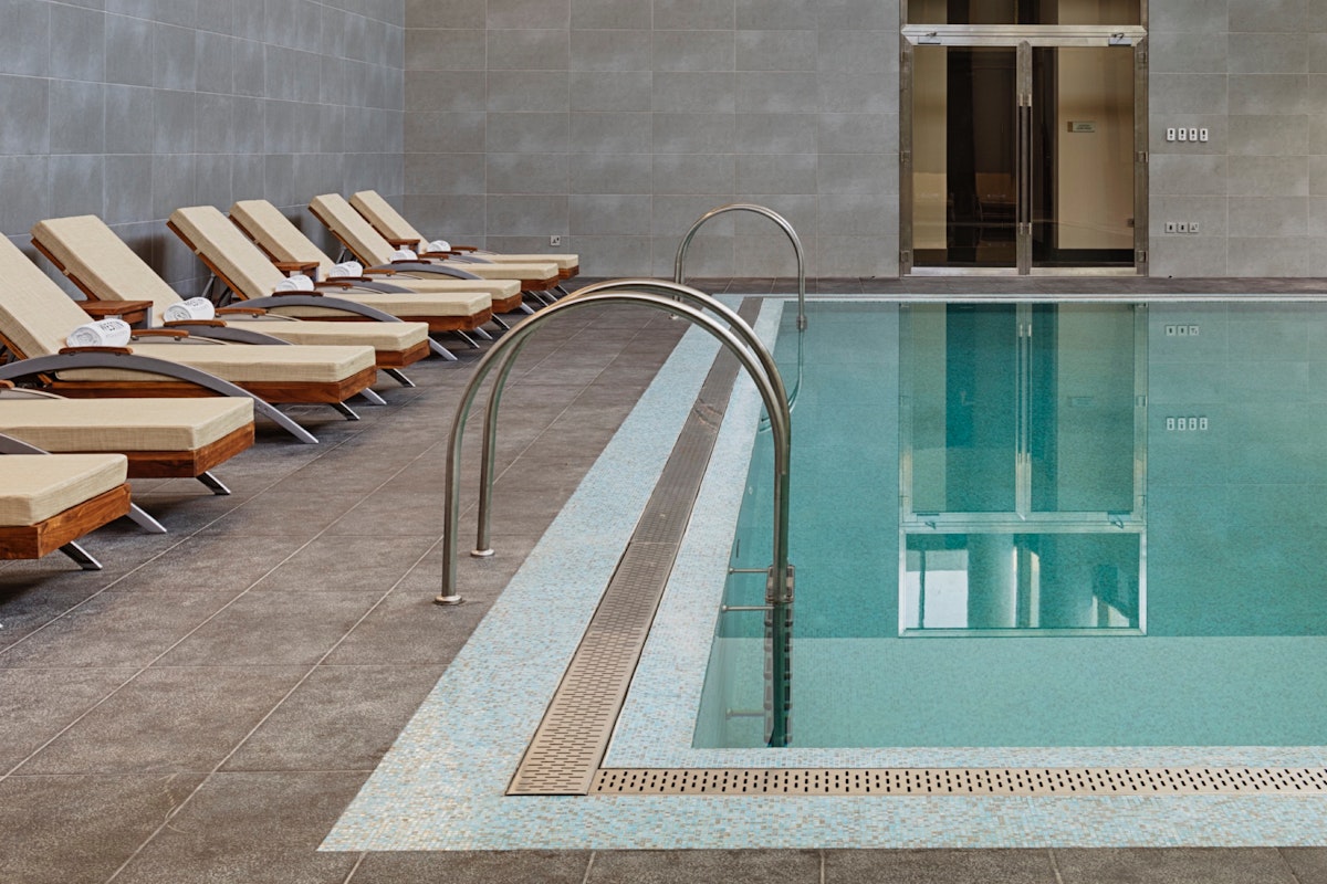 Indoor pool area with lounge chairs and soft lighting.