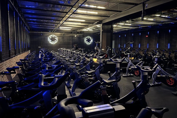 Ride Tribe Spinning studio with rows of stationary bikes, blue neon lights, and industrial-style decor.