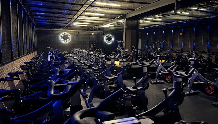 Ride Tribe Spinning studio with rows of stationary bikes, blue neon lights, and industrial-style decor.