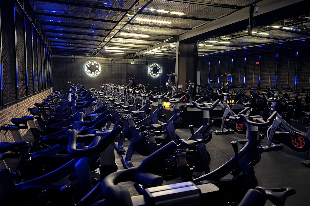 Ride Tribe Spinning studio with rows of stationary bikes, blue neon lights, and industrial-style decor.