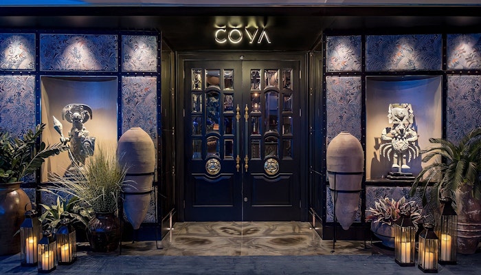 Coya at W Doha Elegant restaurant entrance with decorative plants, sculptures, and soft lighting.