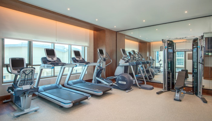 Hilton Doha The Pearl Fitness Center Well-lit gym with treadmills, ellipticals, and a multi-functional machine.