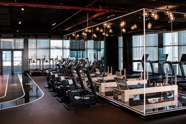 Modern gym with exercise machines and a glass-walled training area