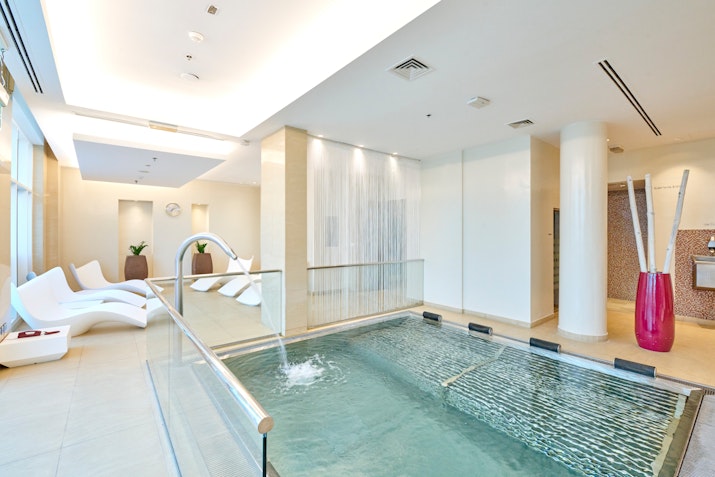 Spa relaxation area with a water feature, lounge chairs, and modern decor.