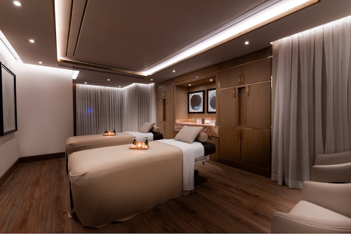 Lavish Spa Services Luxurious spa treatment room with two massage tables, soft lighting, and elegant decor.