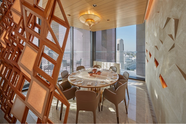 Elegant dining room with a round table, modern decor, and a city view.