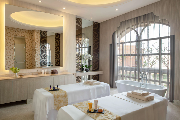 Luxurious spa treatment room with massage tables and a bathtub