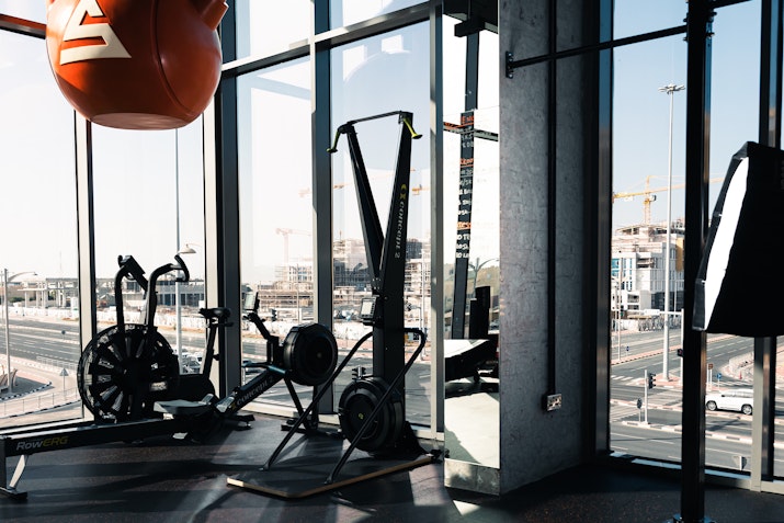 Modern gym equipment with large windows offering a view of the city skyline.