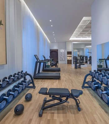The Chedi Katara Hotel & Resort Modern gym with dumbbells, treadmill, and workout equipment.