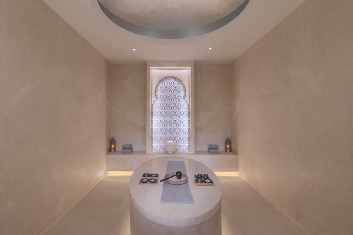 The Chedi Katara Hotel & Resort Serene spa room with a massage table and soft lighting