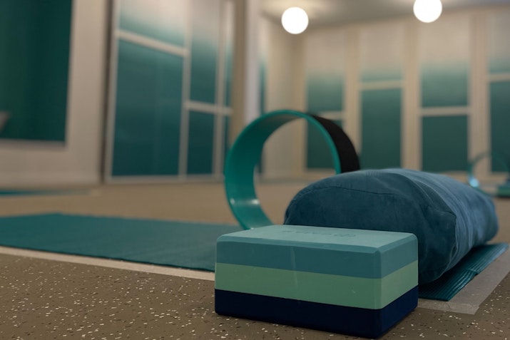 Yoga studio with mats, blocks, and equipment arranged in a peaceful setting.