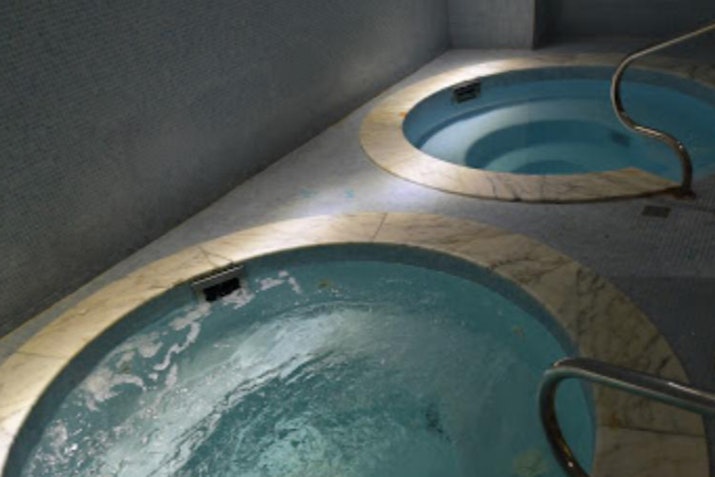 Two jacuzzi tubs with water jets and soft lighting