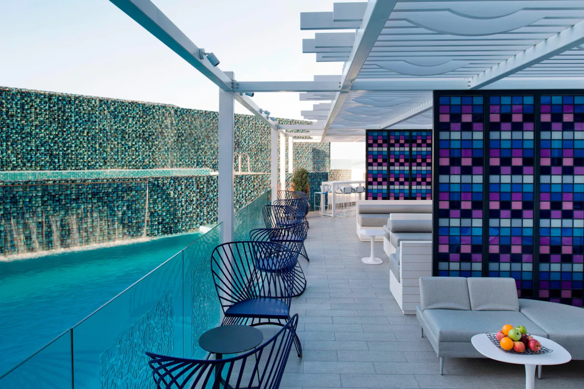 Poolside lounge area with a vibrant waterfall and modern seating.