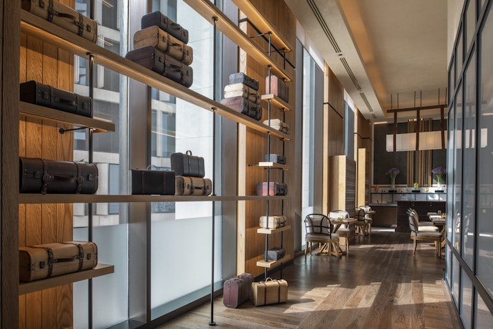 Display shelves with various luggage items in a boutique setting.