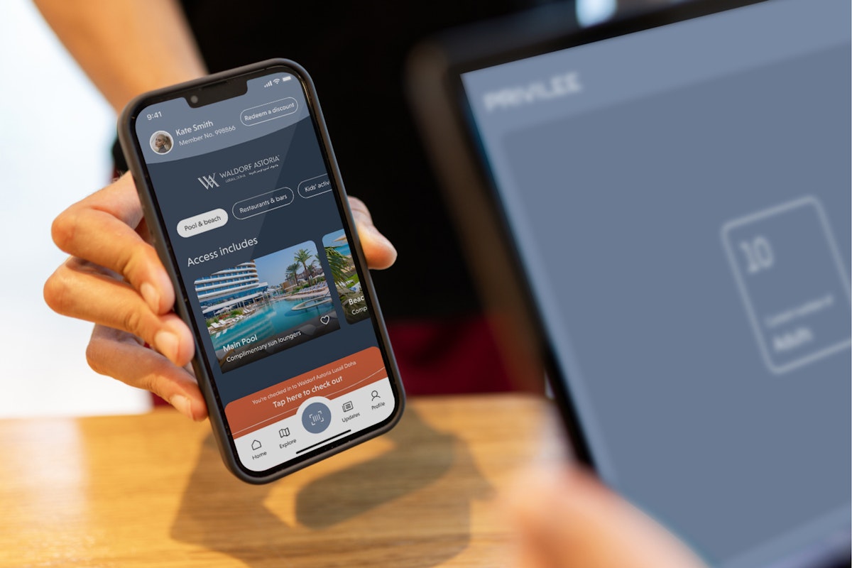 A hand holding a smartphone displaying a mobile app interface with a user's profile and access information.