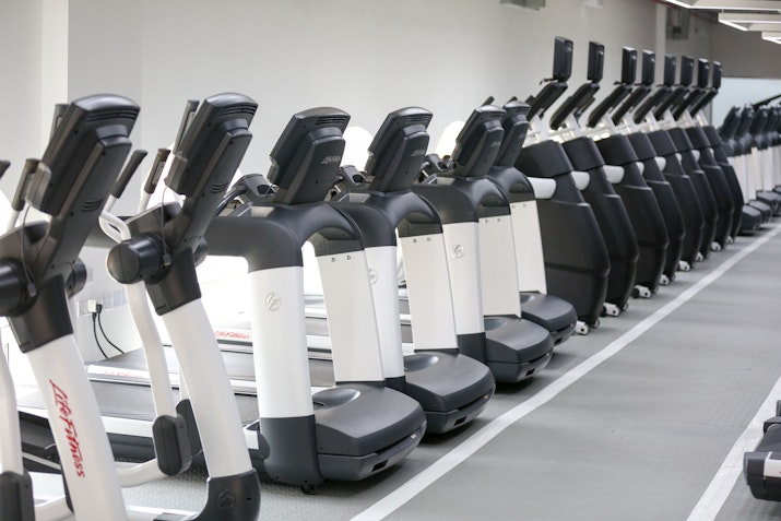 Latest Gym Equipment Row of elliptical machines in a modern gym.