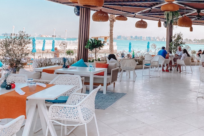 The Four Seasons Hotel Doha Beachside café with outdoor seating and colorful decor