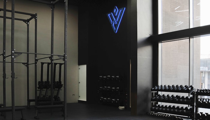 The Vault Fitness Modern gym with dumbbell racks and a fitness studio with branding