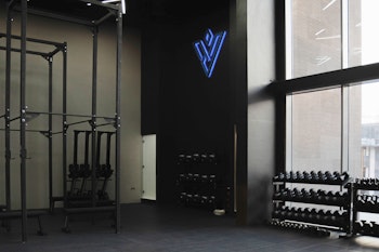 Modern gym with dumbbell racks and a fitness studio with branding