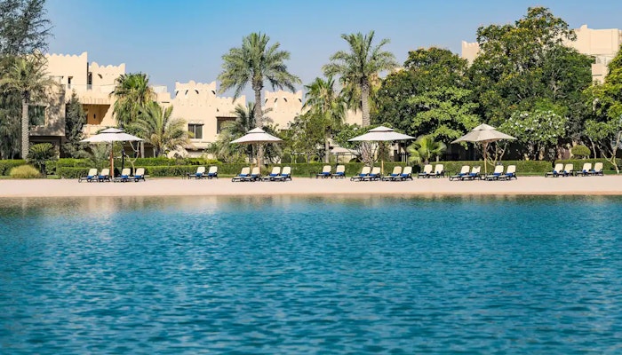 Grand Hyatt Doha Beach with blue water and sun loungers