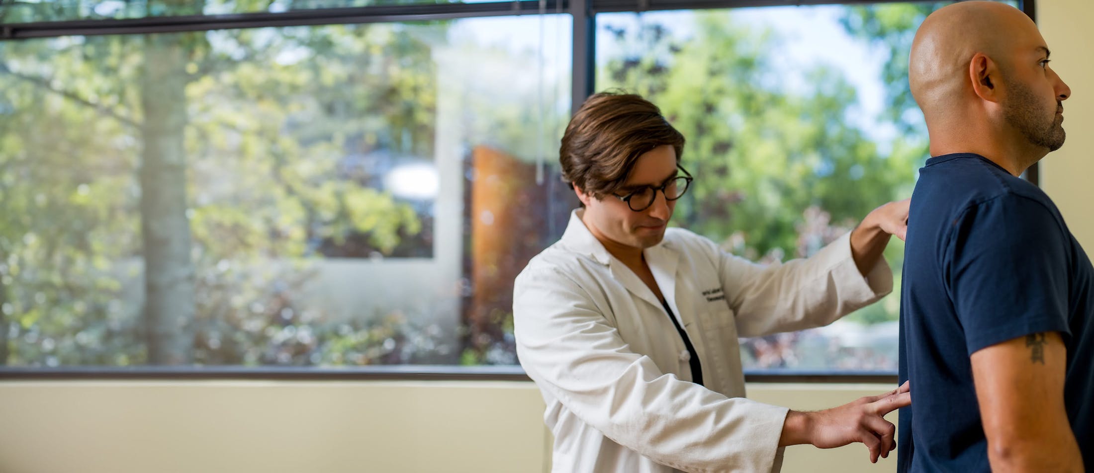 doctor checking a male patient's spine