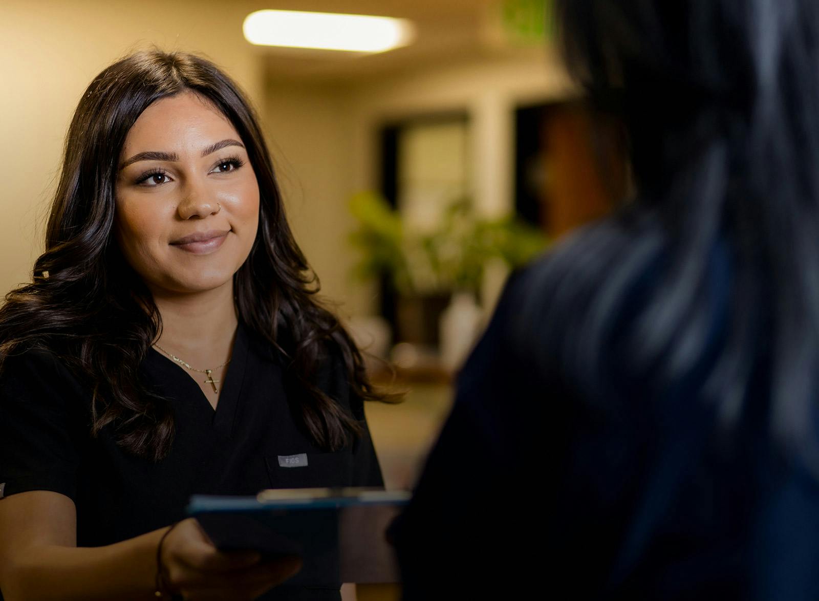 staff handing a patient a clipboard