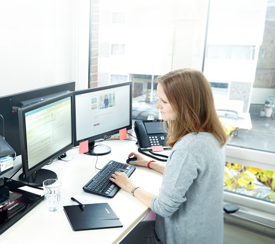 Surplex employee in front of a computer