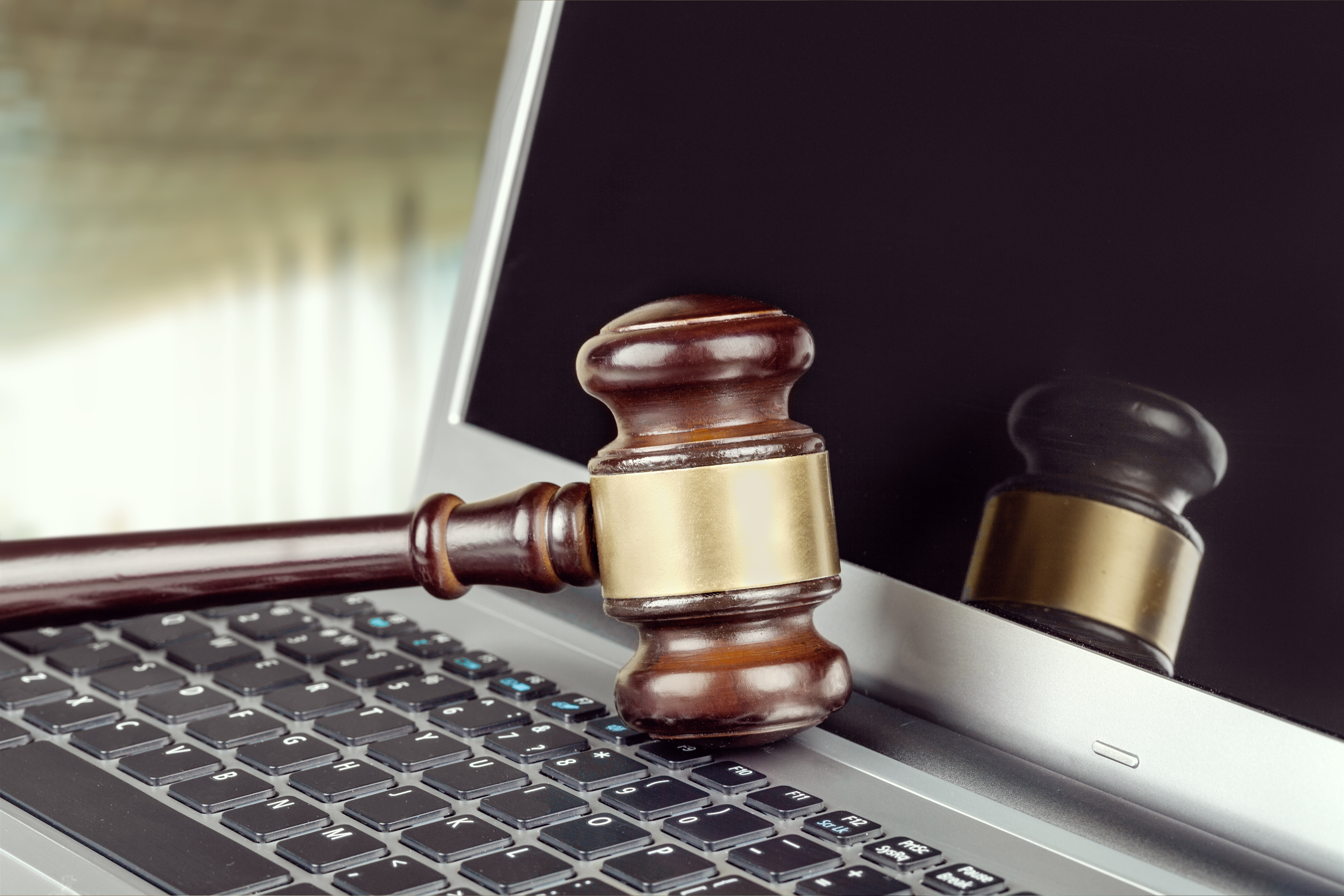 A laptop and auction hammer symbolising the digital transformation of auctions.