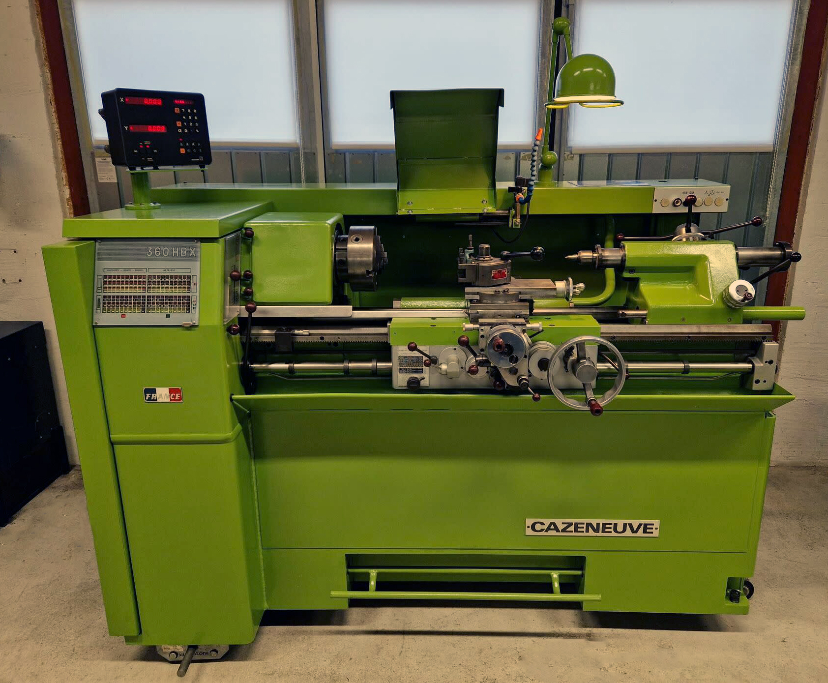 A restored green lathe showcasing industrial history and thoughtful workplace design, combining tradition with functionality.