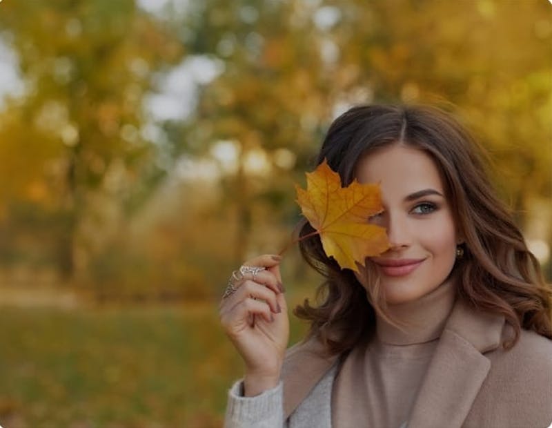 Woman holding a leaf over one eye