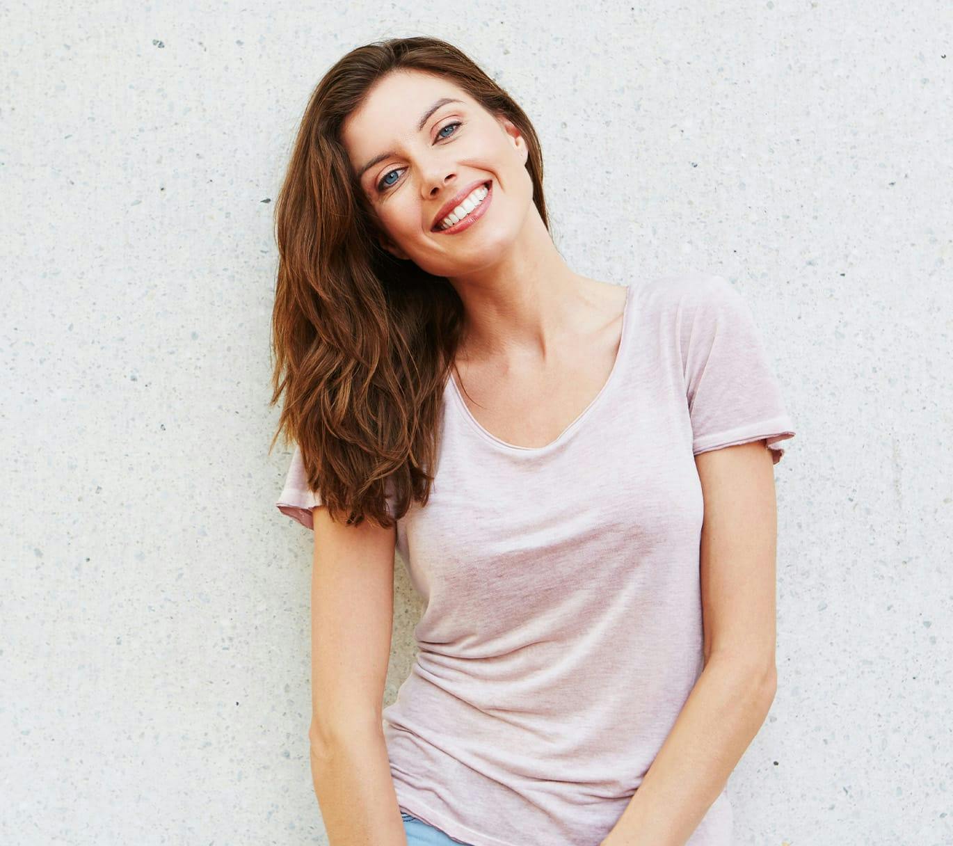 woman smiling and leaning against wall