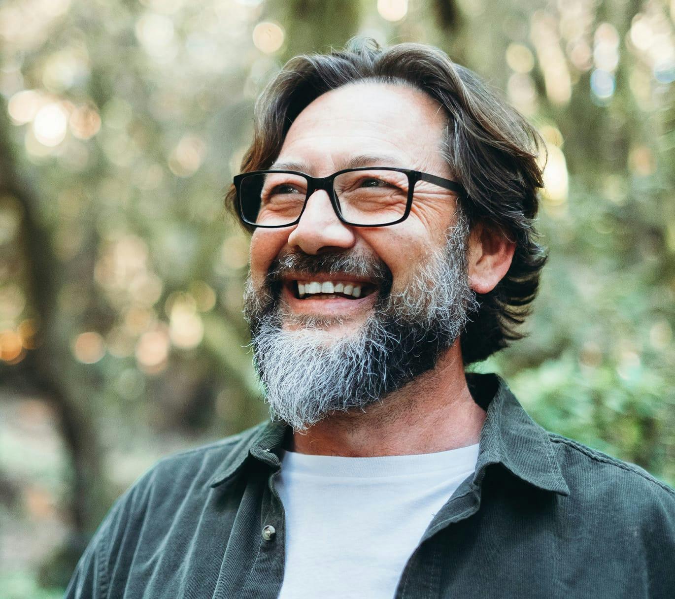 smiling man with glasses standing outside