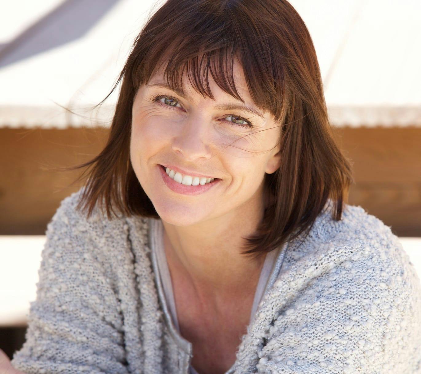 smiling woman outside in knit sweater