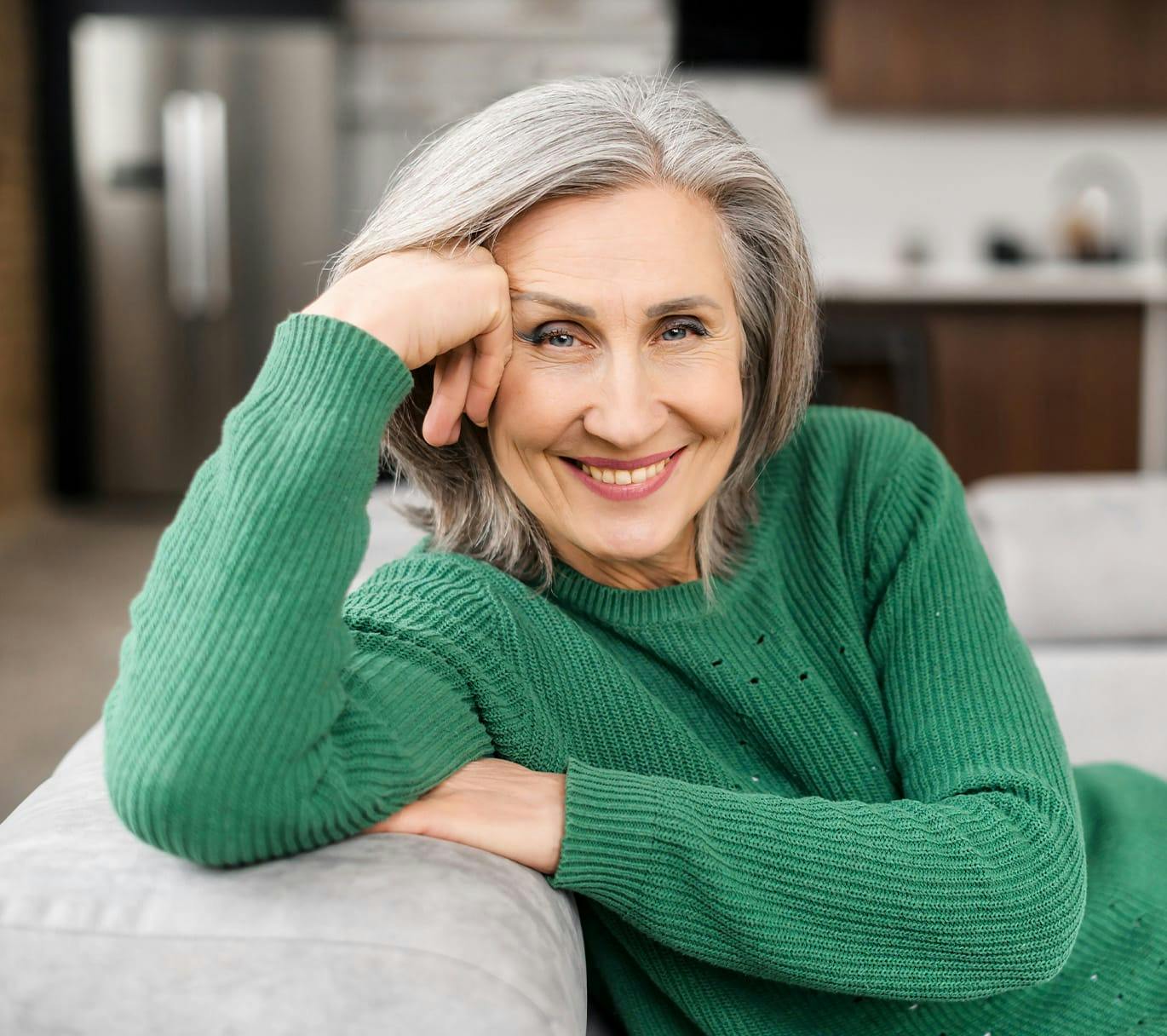 woman smiling with elbow on couch