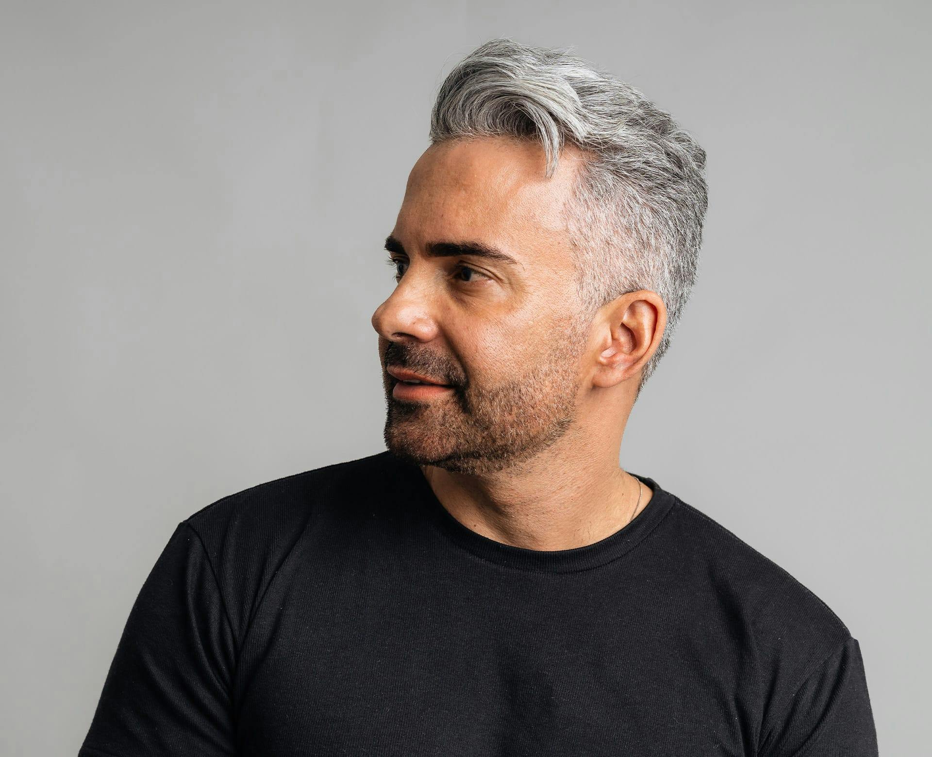 man with grey hair looks to the side