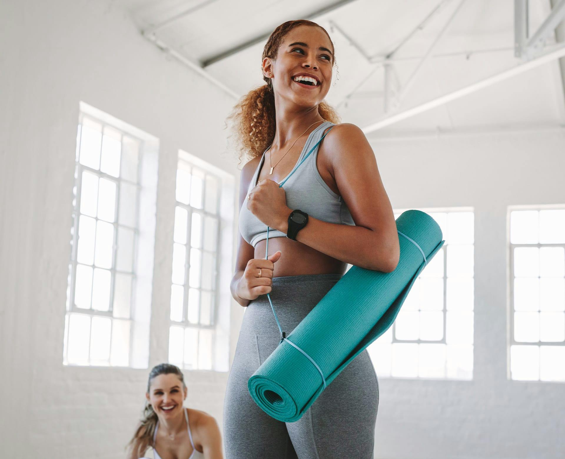 woman carrying workout mat