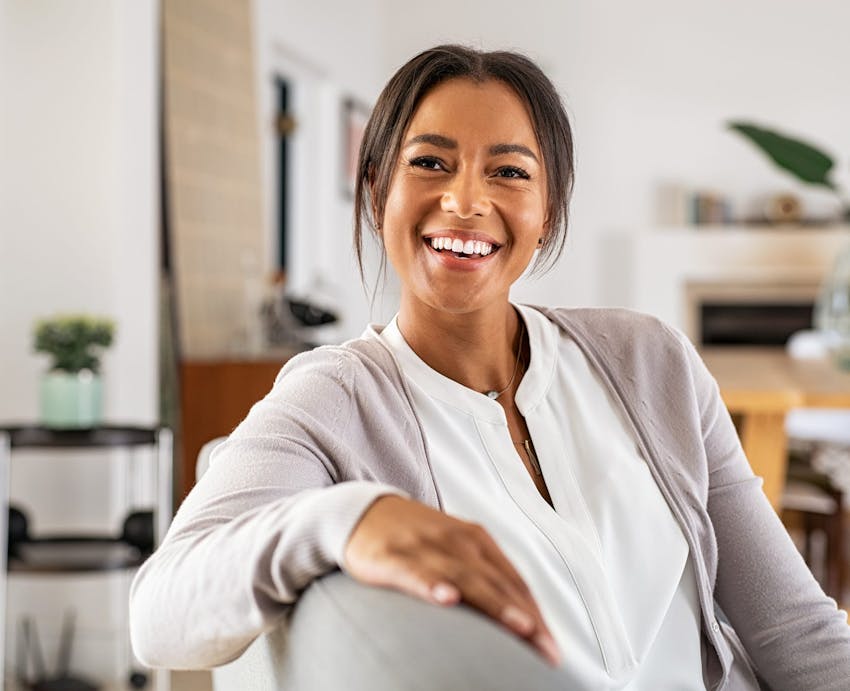 woman smiling with arm on chair