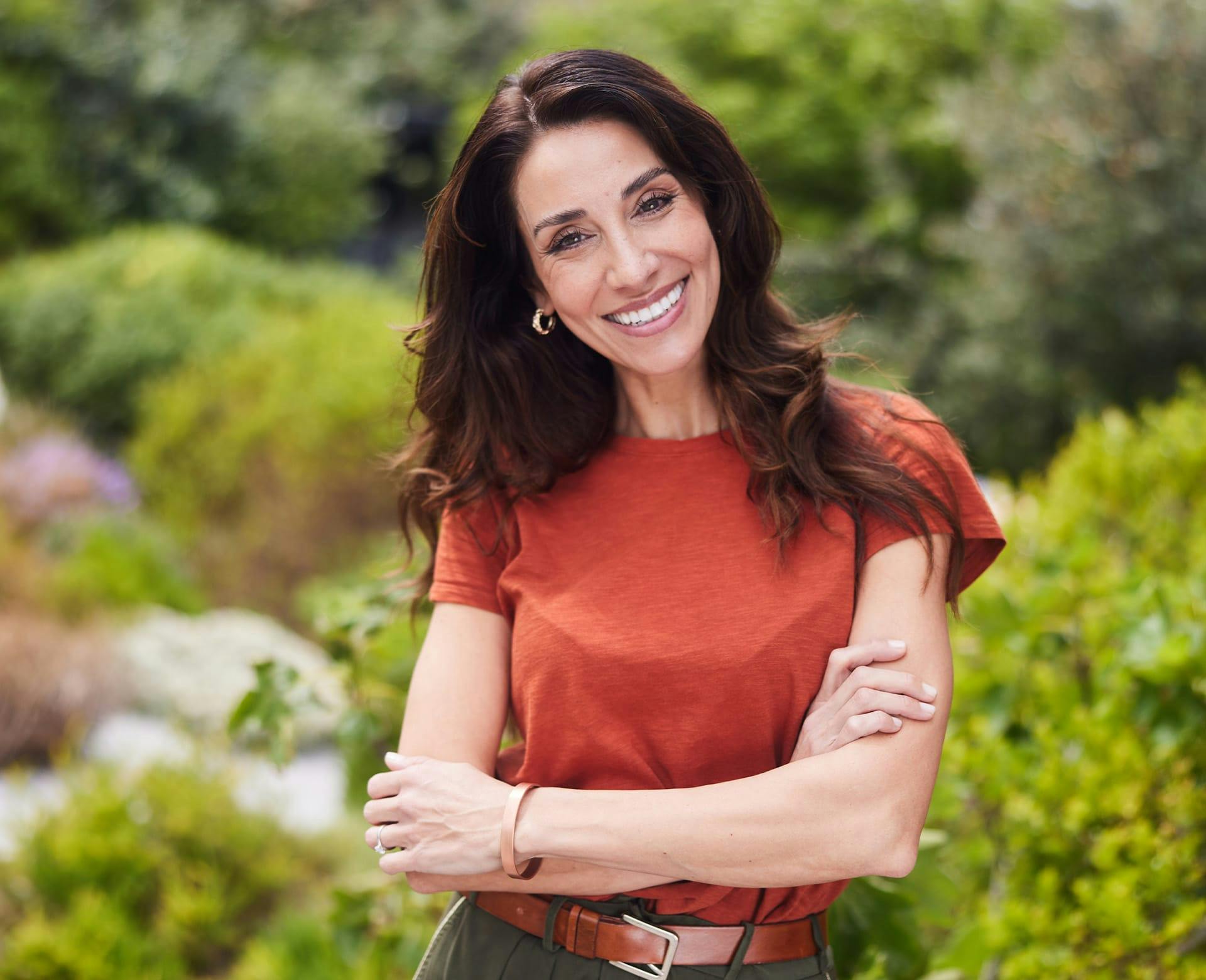 smiling woman outside with arms crossed