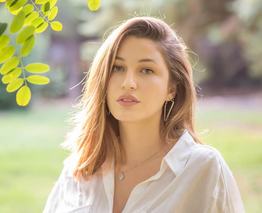 woman standing under tree branch