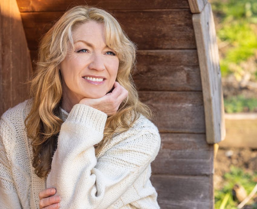 smiling woman sitting on a wooden bench