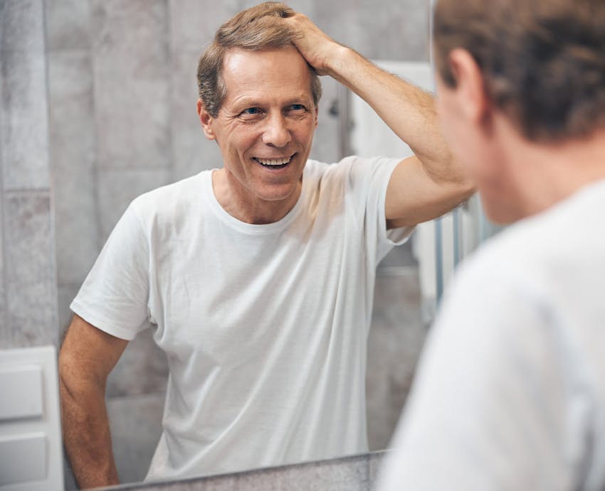 smiling man looking in the mirror