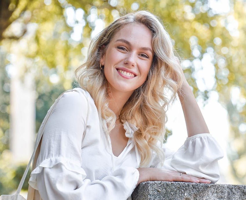 woman leaning on cement pillar