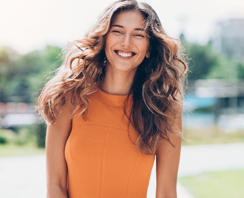 woman in an orange shirt smiling